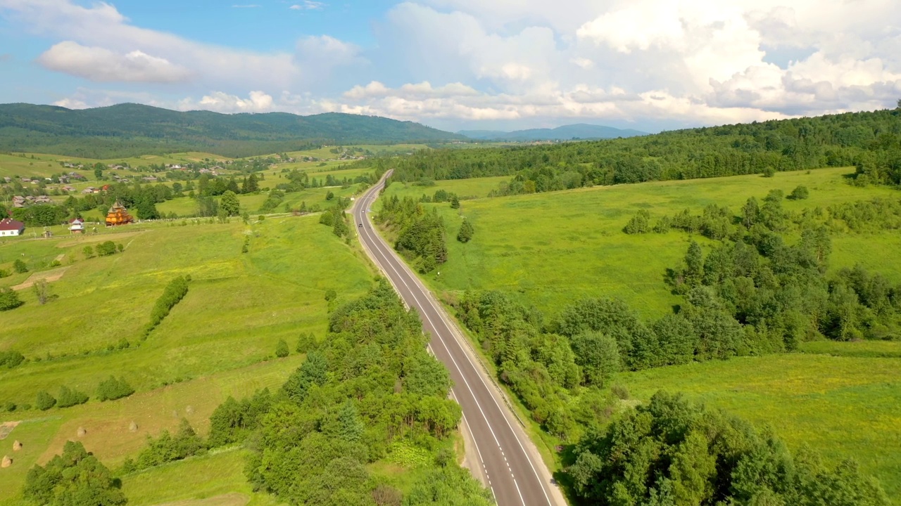 一架无人机飞过一条穿越山口的公路时所看到的壮丽景色。视频素材