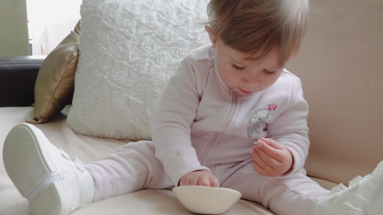 宝宝坐在沙发上吃饼干。视频下载