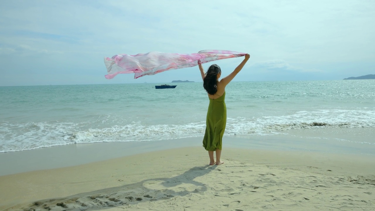 沙滩上挥舞围巾的女人视频素材