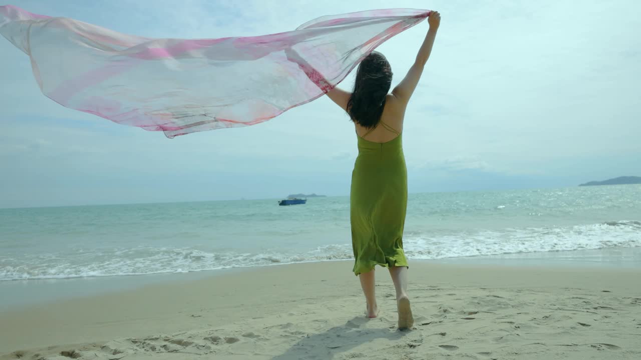 沙滩上挥舞围巾的女人视频素材