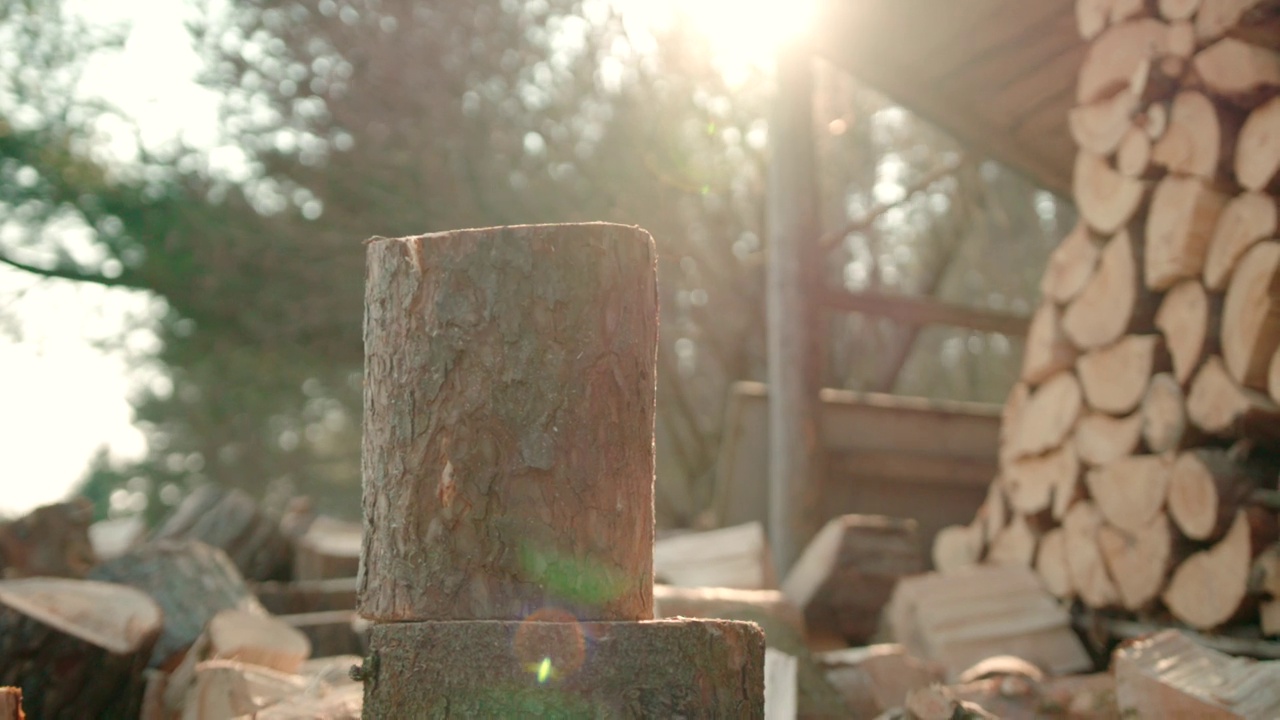 慢镜头:阳光背景下用斧头劈木头视频素材