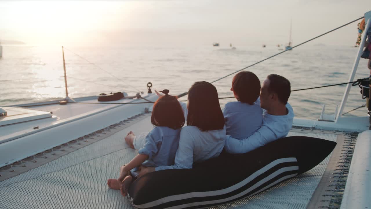 幸福的亚洲家庭在日落时分的游艇上度过美好的时光视频下载
