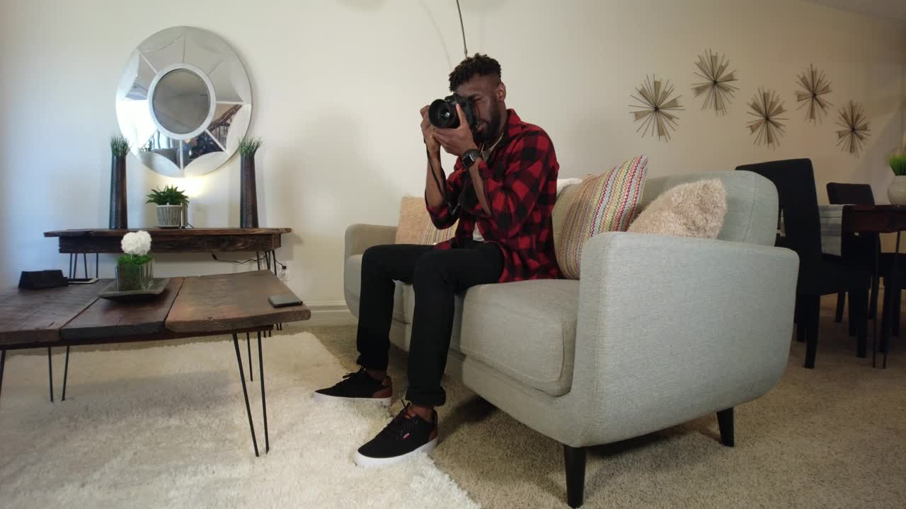 学习数码单反相机按下播放观看DIY视频年轻黑人非洲男性美国西部视频系列视频素材