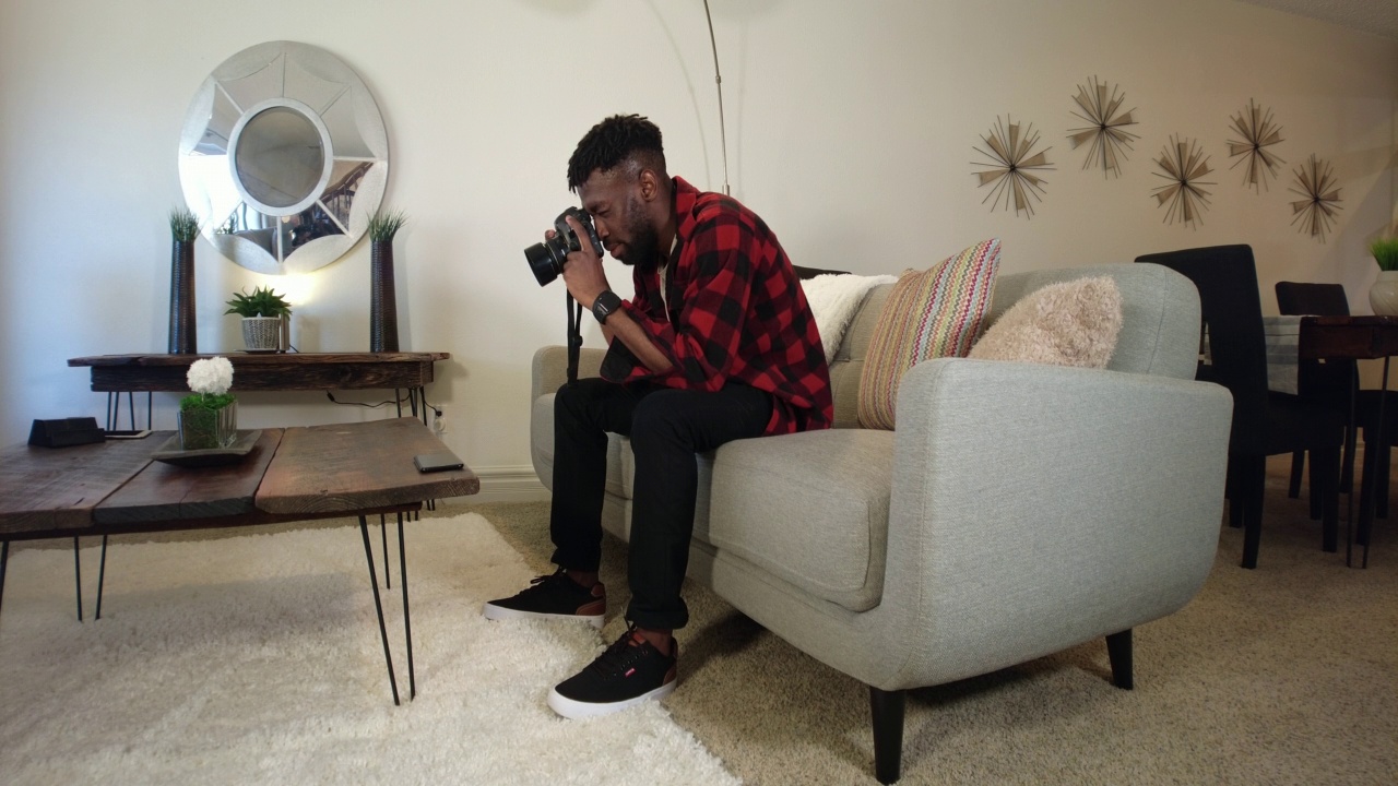 学习数码单反相机按下播放观看DIY视频年轻黑人非洲男性美国西部视频系列视频素材