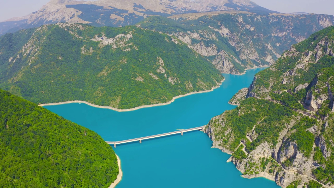 在皮瓦湖上的桥梁与黑山的山脉峡谷的鸟瞰图。视频素材