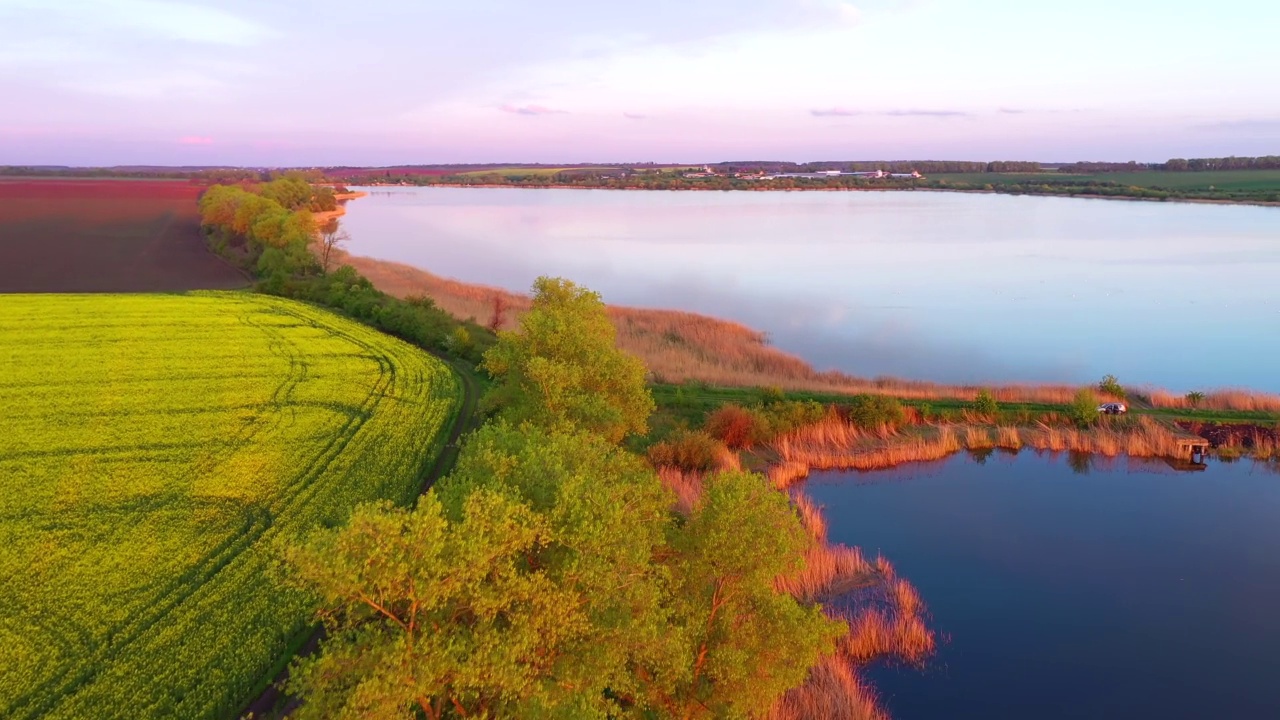美丽的景色，平静的湖和耕田在阳光下在晚上。视频素材