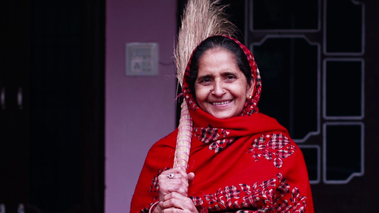 印度女子手持扫帚，对着镜头微笑视频下载