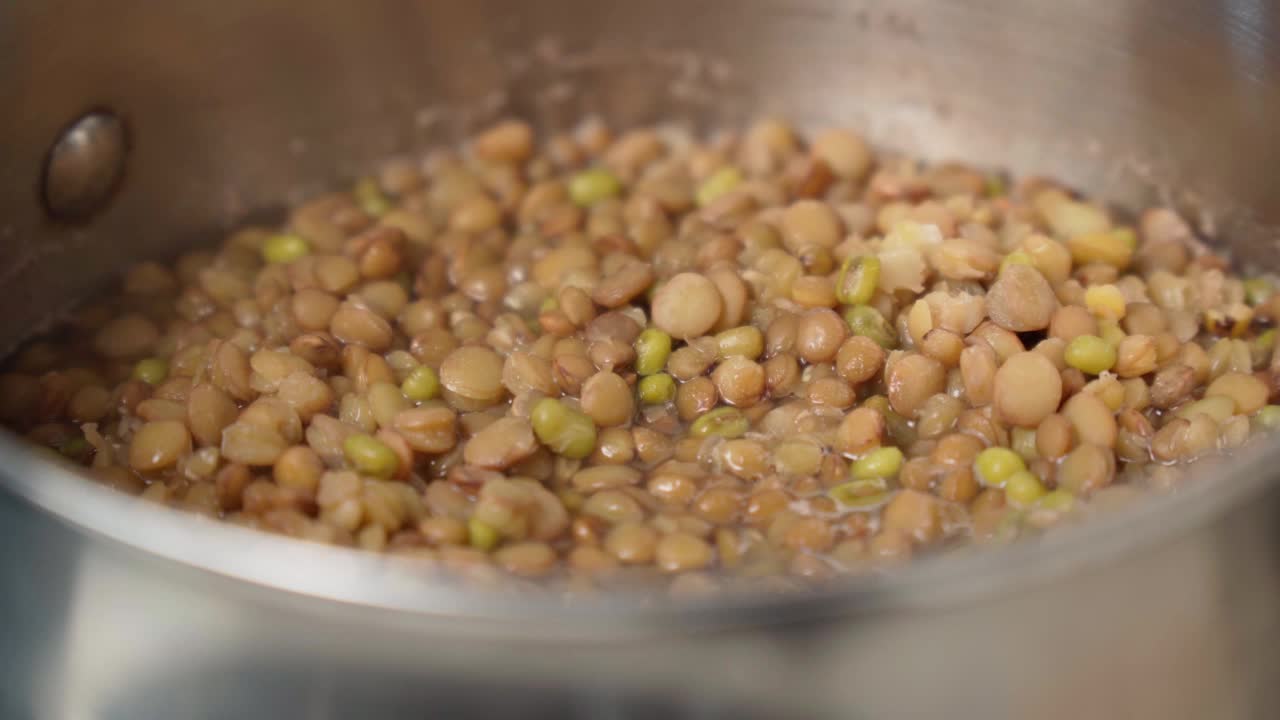 烹饪棕扁豆特写镜头，选择性聚焦。一个素食者的健康饮食的有机产品视频素材