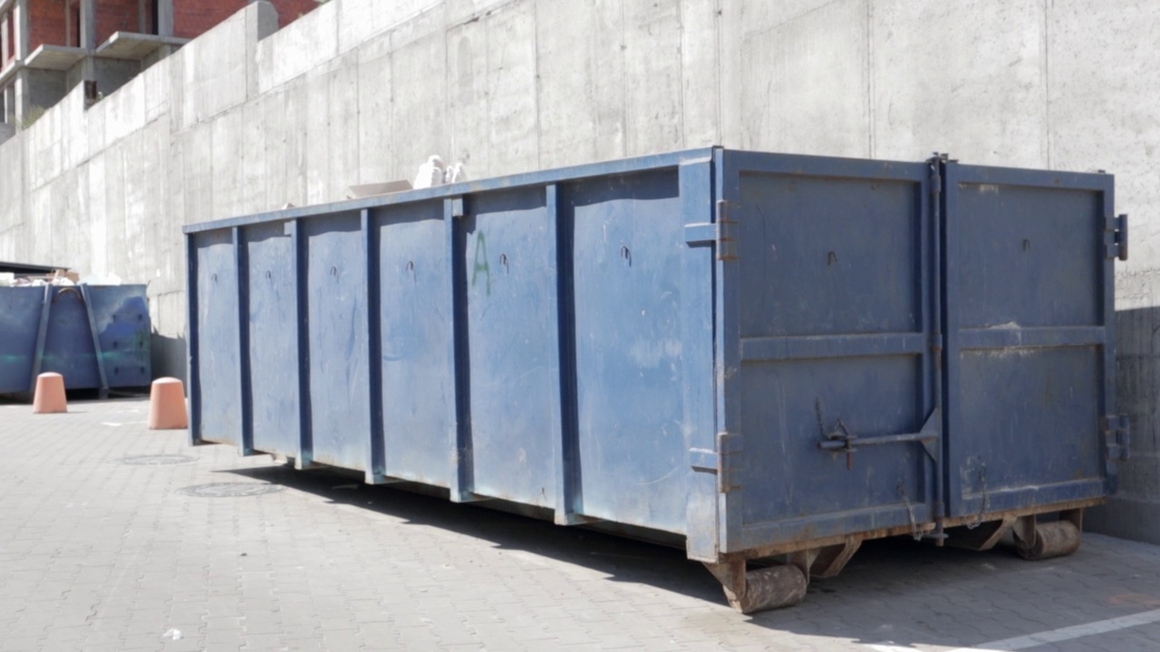 蓝色金属耐用工业垃圾桶，用于建筑工地的户外垃圾。大型废物篮，用于放置家庭或工业废物。一堆废物视频素材
