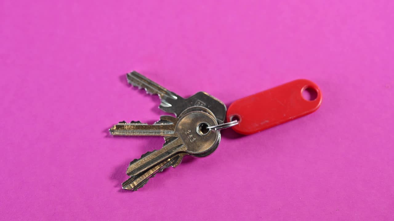一个男人拿走了放在粉红色桌子上的钥匙。视频下载
