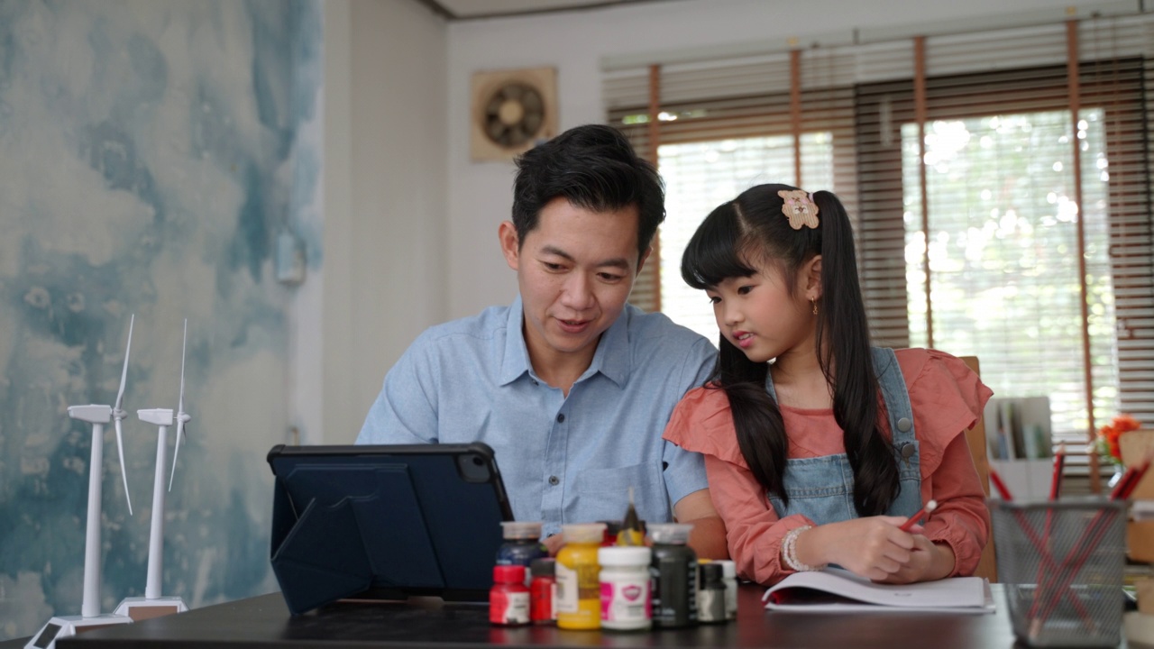 在家上学的女孩与她的父亲在家里学习清洁能源和可持续性视频素材
