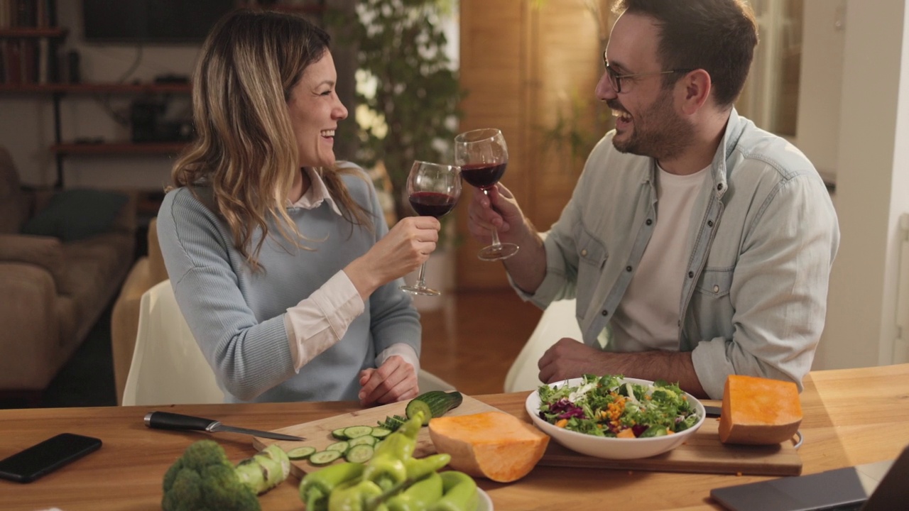 幸福的夫妇在家里做健康的饭菜。视频素材