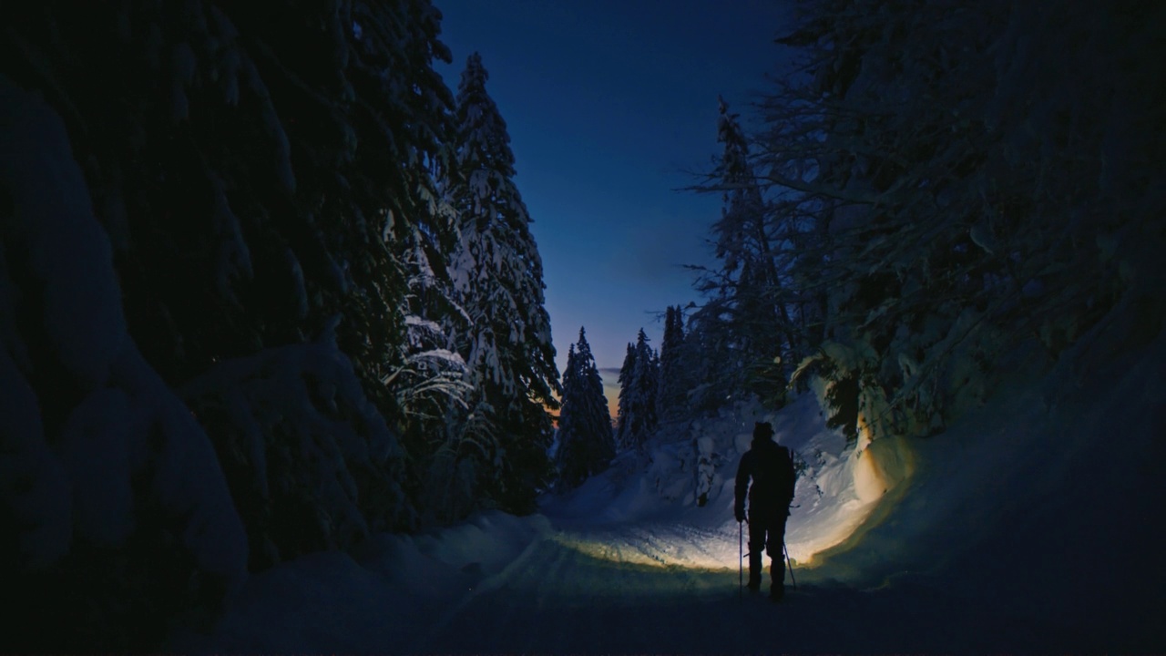 夜深人静的徒步旅行者漫步在冬日的森林里视频下载