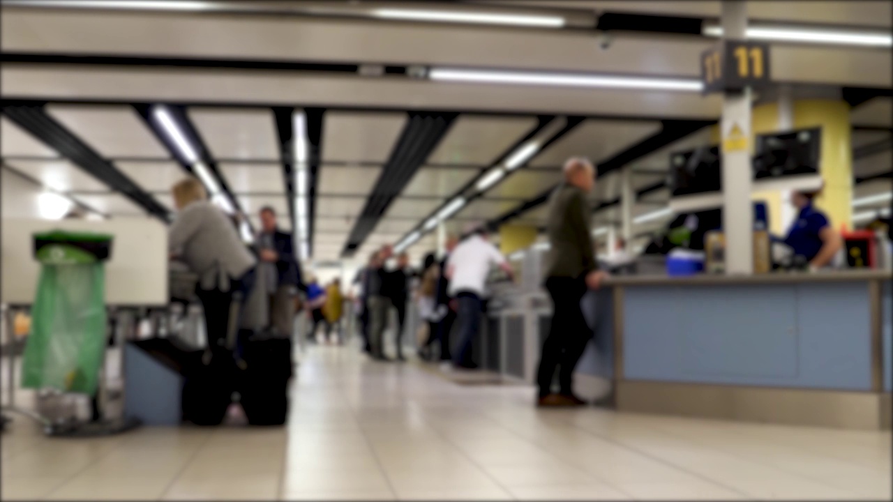 机场安全行李检查的4k模糊离焦剪辑，无法辨认的人在登机前在机场航站楼通过标准安全检查视频素材