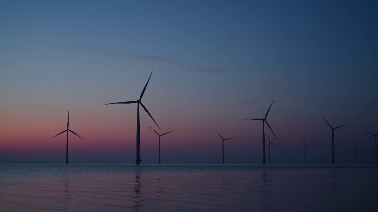 日落时分，海上风力公园的风力涡轮机生产可持续的可再生能源。视频素材