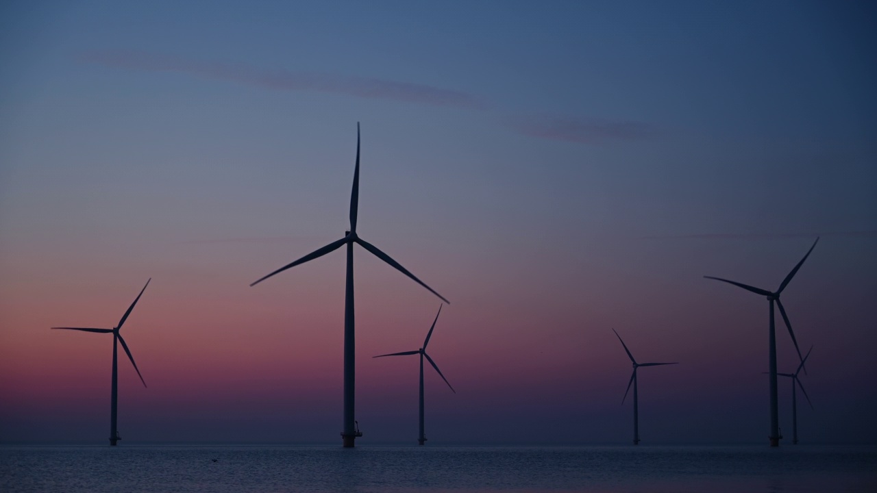 日落时分，海上风力公园的风力涡轮机生产可持续的可再生能源。视频素材