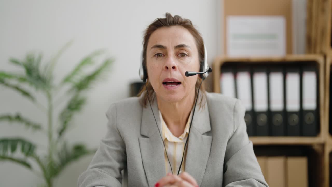 中年妇女呼叫中心接线员在办公室讲话视频素材