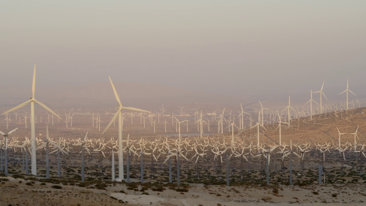 空中拍摄的旋转的风车，在沙漠的山丘上，在晴朗的天空下-棕榈泉，加利福尼亚视频素材
