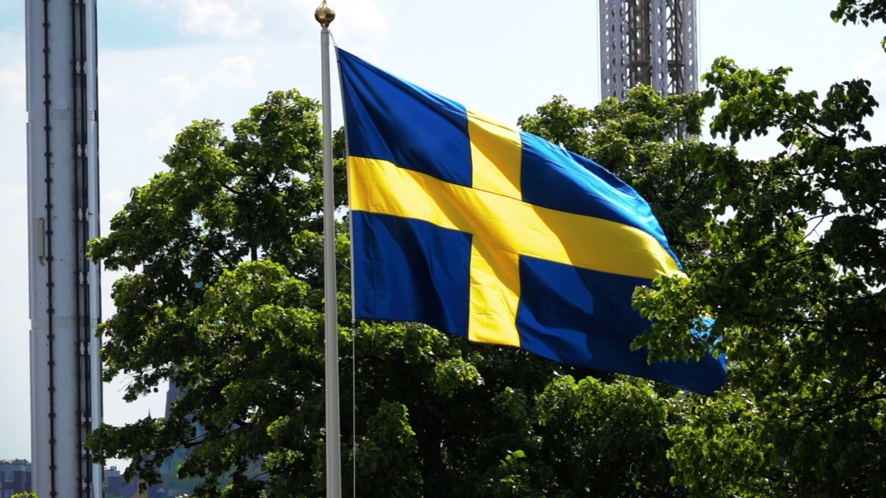 封锁慢动作拍摄的瑞典国旗在阳光下挥舞的杆子-斯德哥尔摩，瑞典视频下载