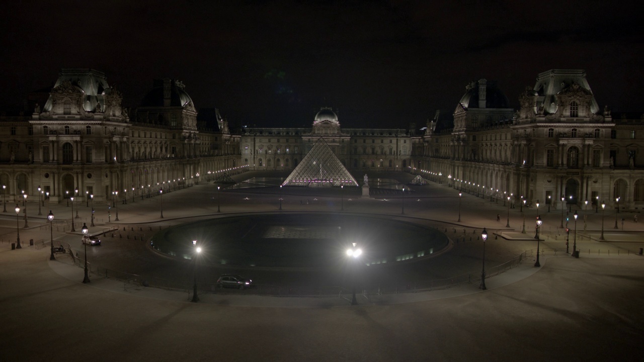 卢浮宫博物馆和玻璃金字塔的广角。汽车行驶在杜卡鲁塞尔广场交通圈在博物馆前可见。视频素材