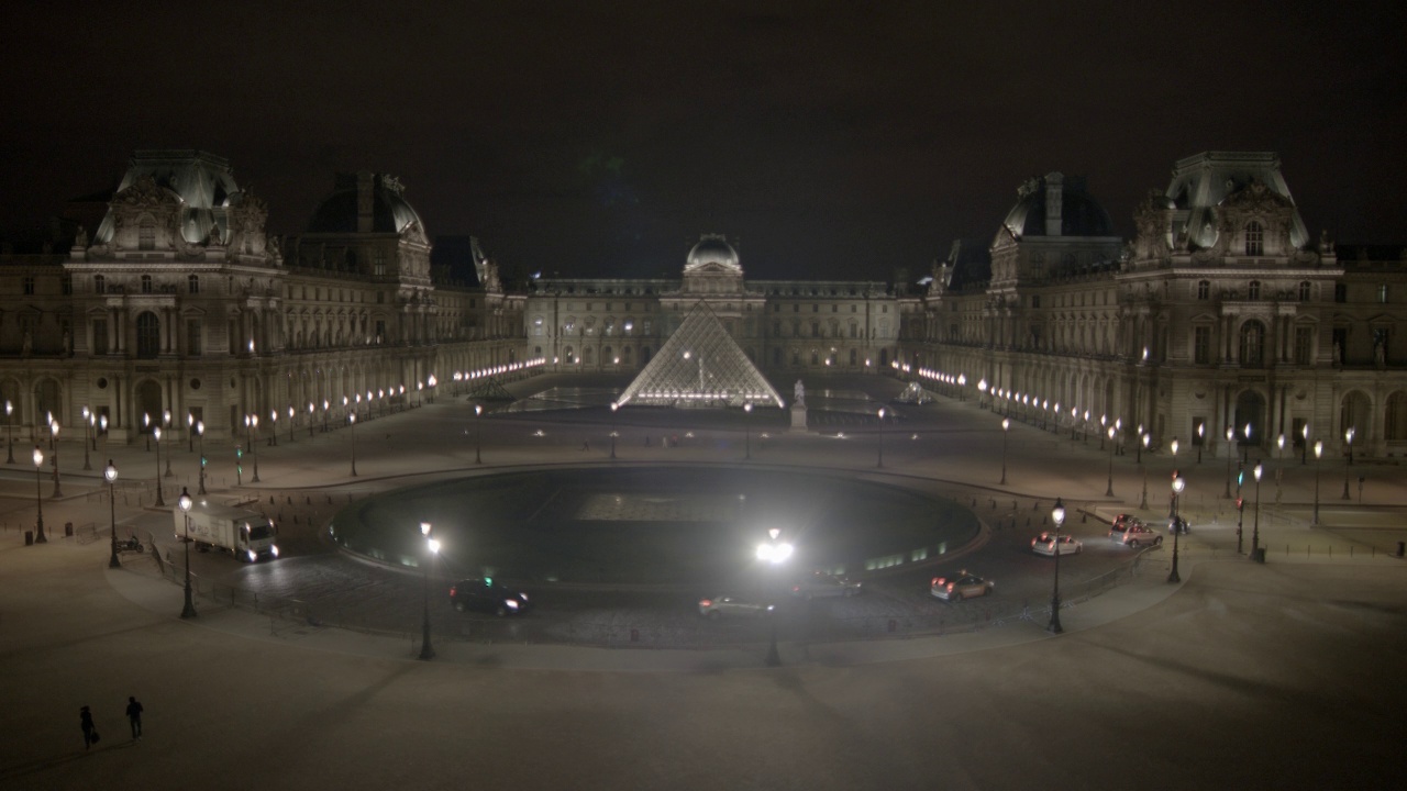 卢浮宫博物馆和玻璃金字塔的广角。汽车行驶在杜卡鲁塞尔广场交通圈在博物馆前可见。视频素材