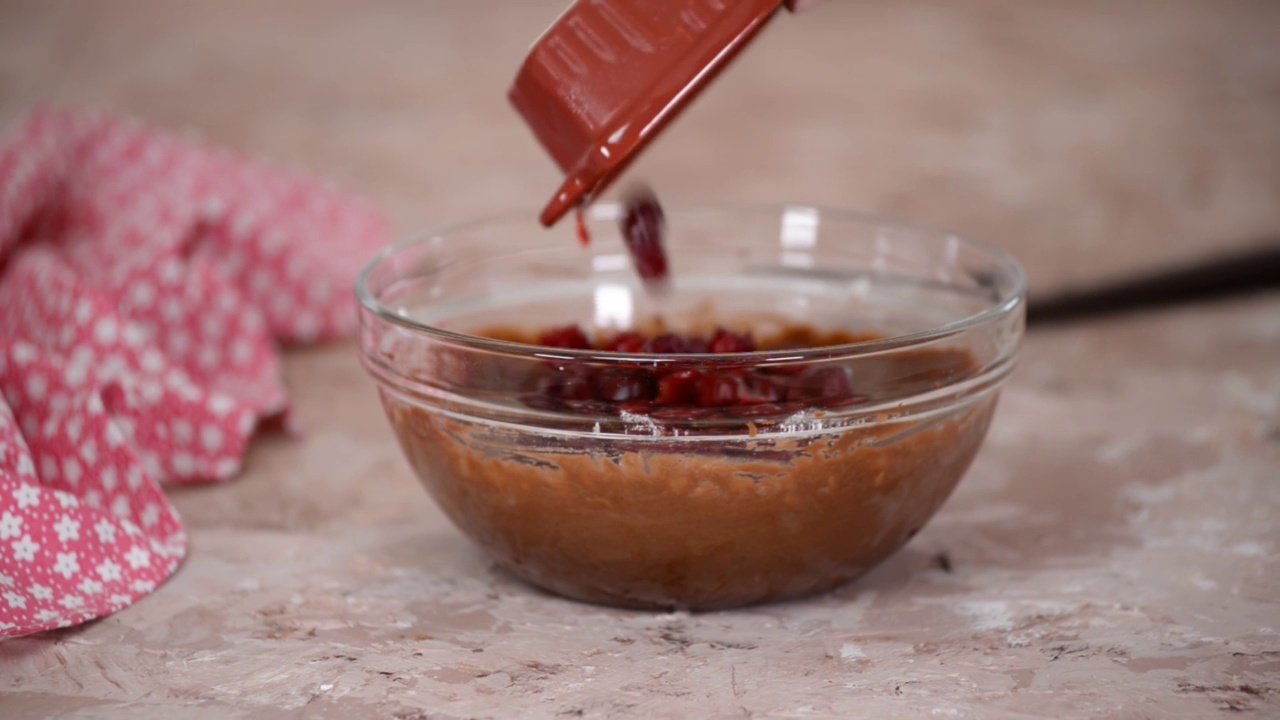 在巧克力面糊中加入樱桃，制作美味的自制布朗尼蛋糕。视频素材