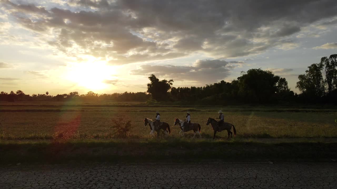 日落时分，牛仔在草地上骑马视频素材