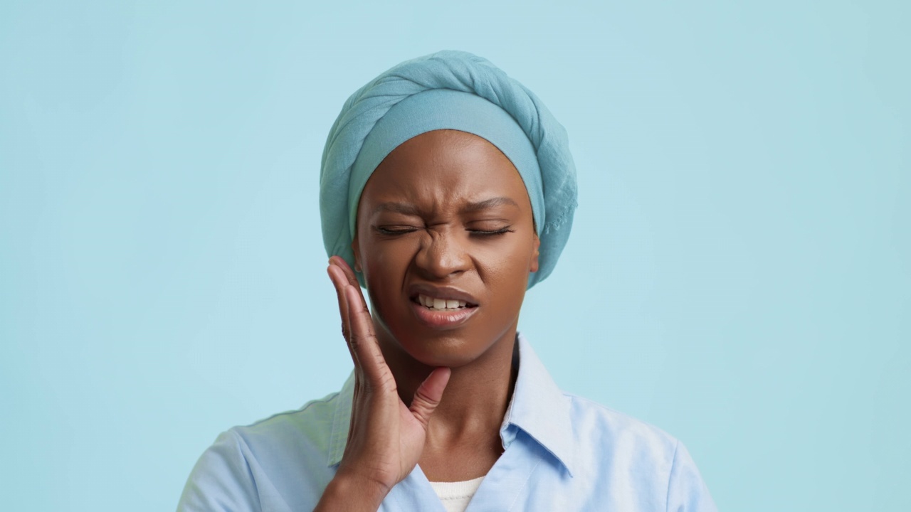 忧郁的非洲裔美国女性牙痛的蓝色背景视频下载