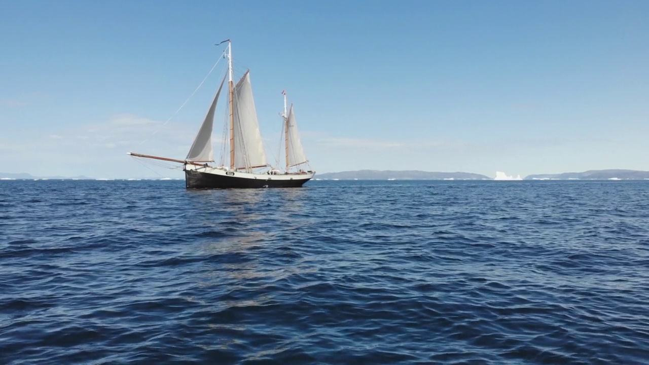 船与帆航行在阳光明媚的蓝色海洋格陵兰视频素材