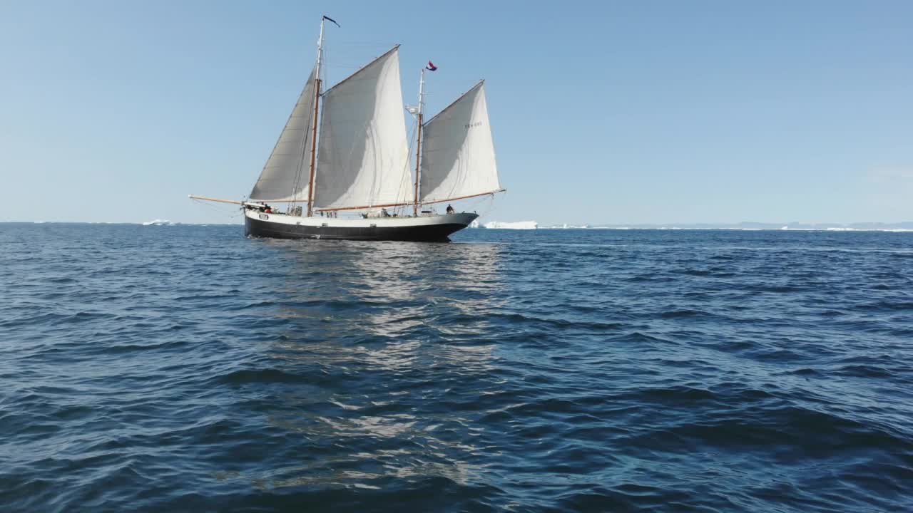 船与帆航行在阳光明媚的蓝色海洋格陵兰视频素材