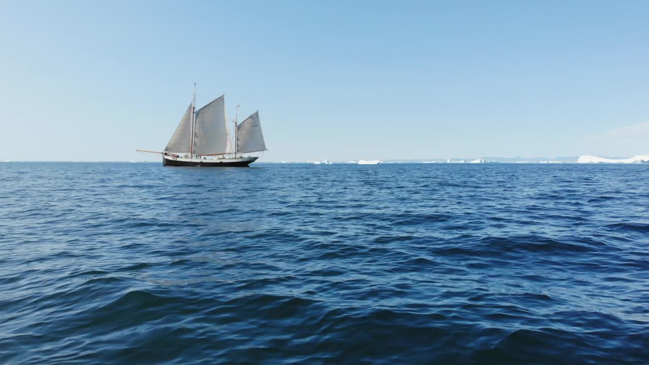 船沿着阳光明媚的蓝色海洋格陵兰航行视频素材