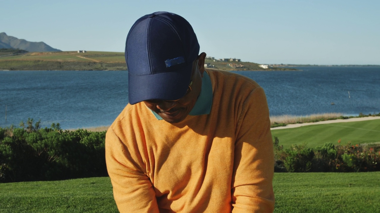 男高尔夫球手在阳光明媚的湖边高尔夫球场练习开球视频下载