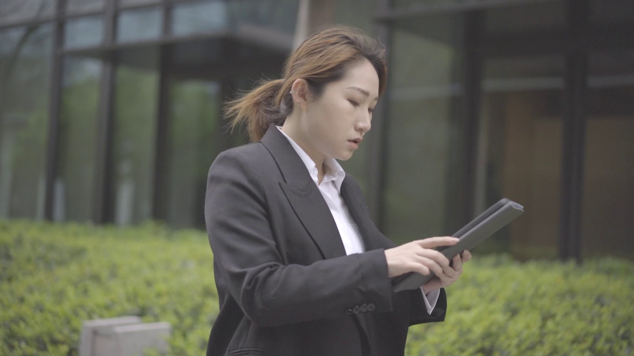 横拍的现代年轻商业亚洲妇女一边工作一边走，匆忙而焦虑视频下载