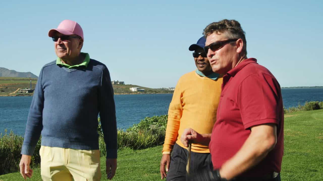 退休的男性高尔夫球手准备在阳光明媚的湖边高尔夫球场开球视频下载