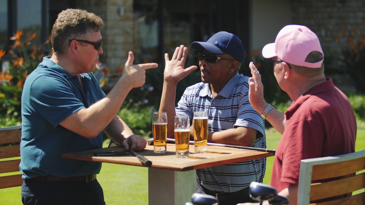 男性高尔夫球手在阳光明媚的露台上击掌、喝啤酒视频下载