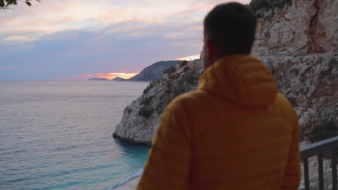 一名男子在土耳其风景如画的海滩上凝视着夕阳视频素材
