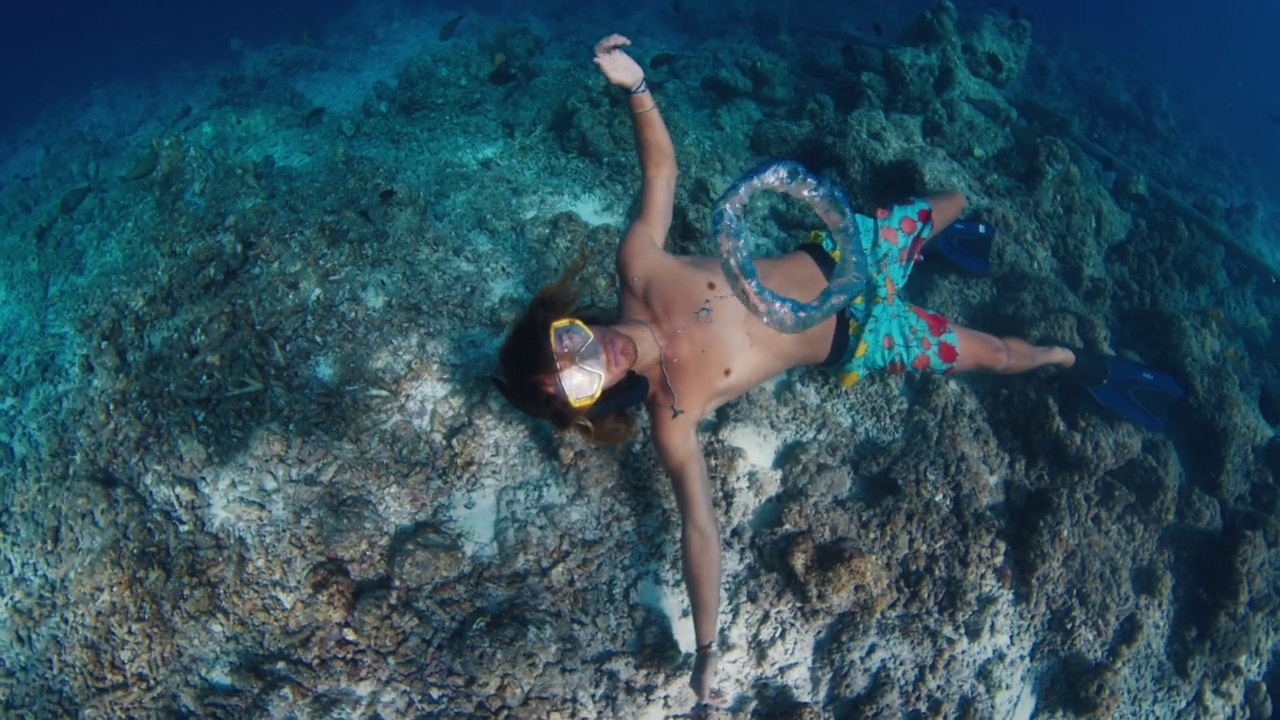 男人在水下吹泡泡。在马尔代夫，自由潜水员在水下游泳，吹环状泡泡视频下载