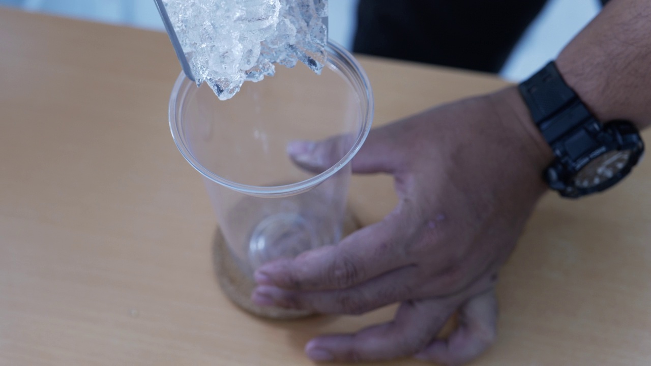 向塑料杯中倒入冰块。视频素材