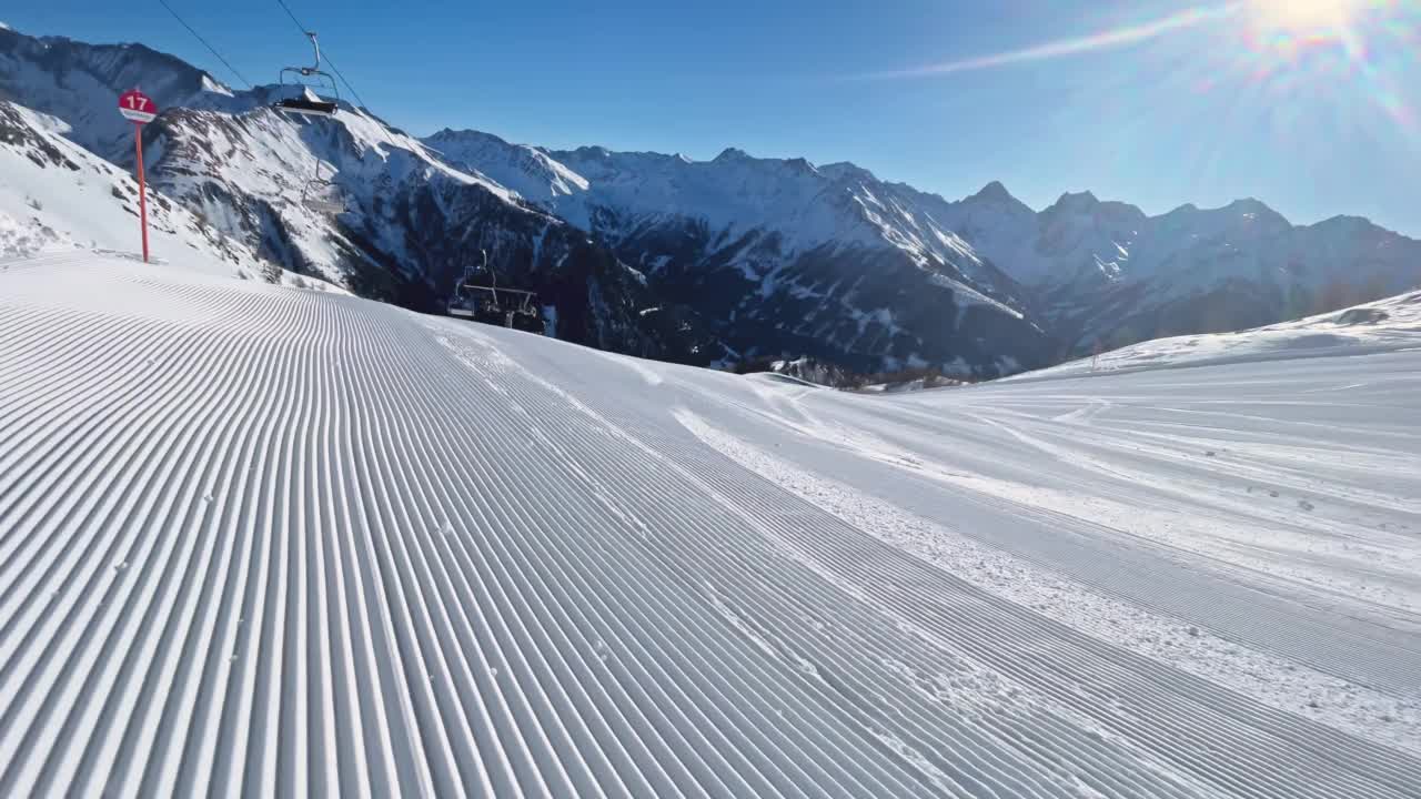 阳光下，在崭新的滑雪坡上滑雪视频下载