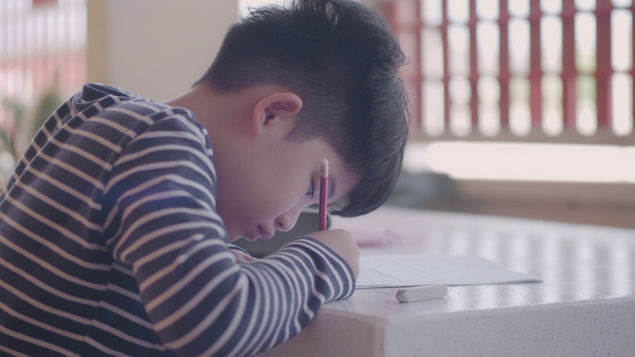 亚洲男孩在家做家庭作业视频素材
