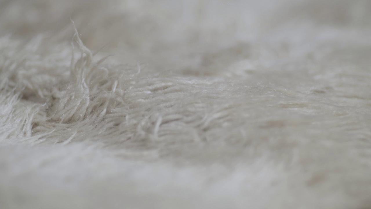 山羊绒地毯的抽象质地，白色羊毛地毯，用作毯子或沙发盖视频下载