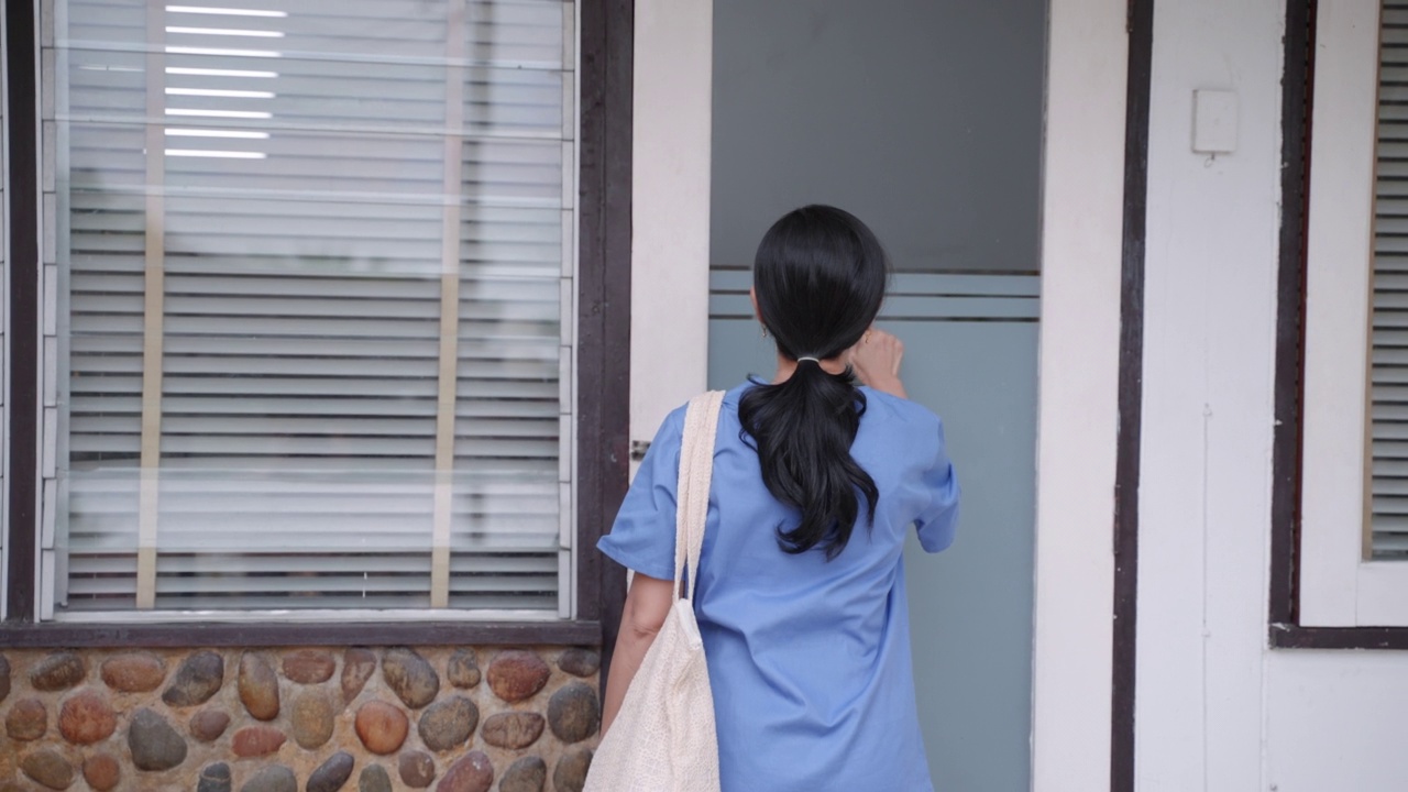 亚洲女护士身着蓝色制服抵达老年女病人家中视频下载