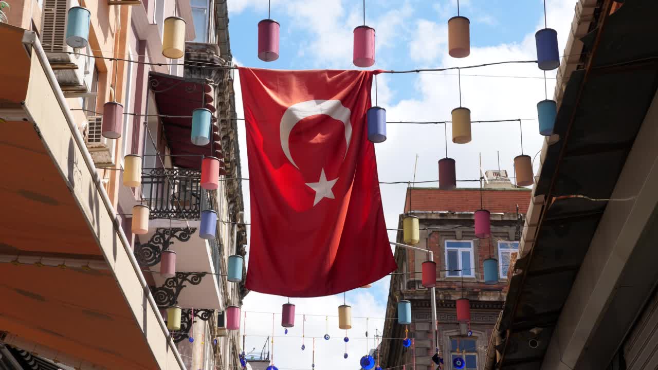 在卡拉科伊，土耳其国旗悬挂在建筑物之间的电线上，阳光照耀着它视频下载