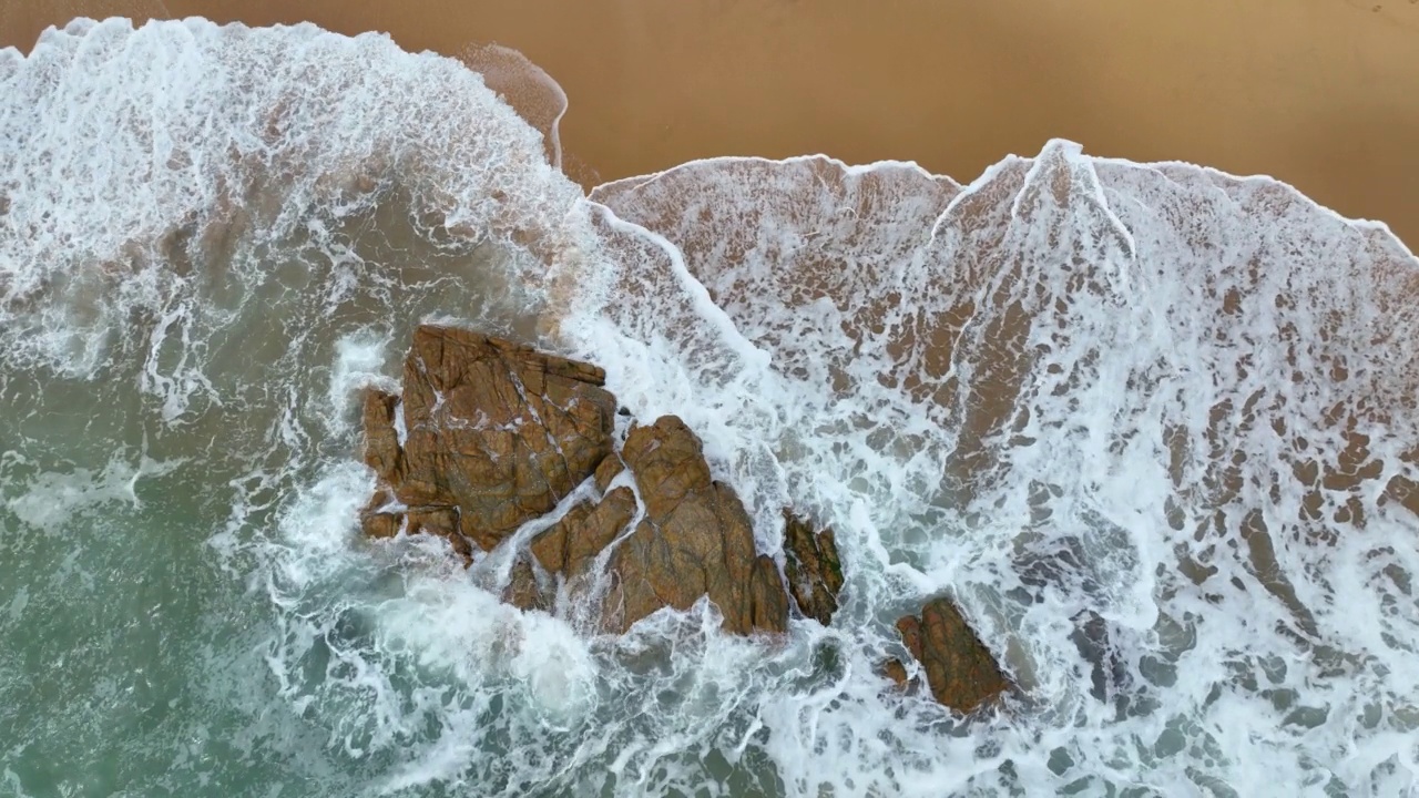鸟瞰图，海岸线的波浪拍打着岩石视频素材