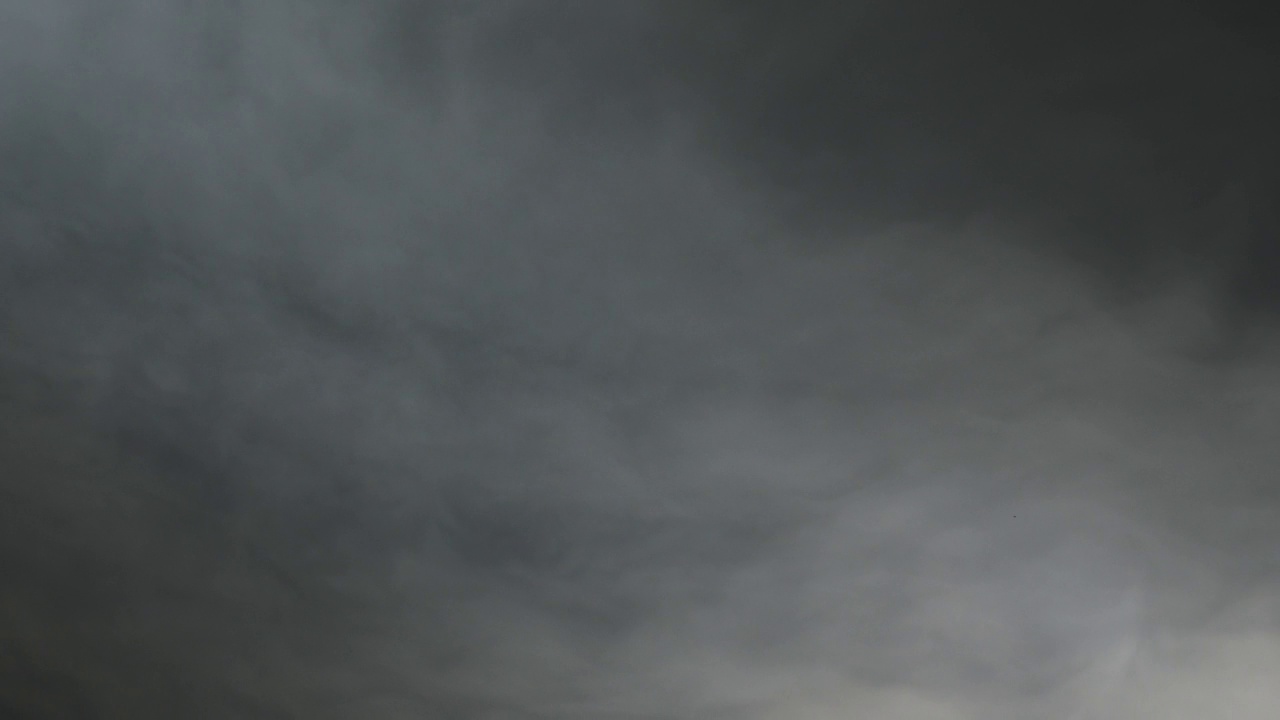 戏剧性的雨云在灰色的天空上快速移动。雷暴云朵映着灰色的天空，时间流逝。多雨的cloudscape视频素材