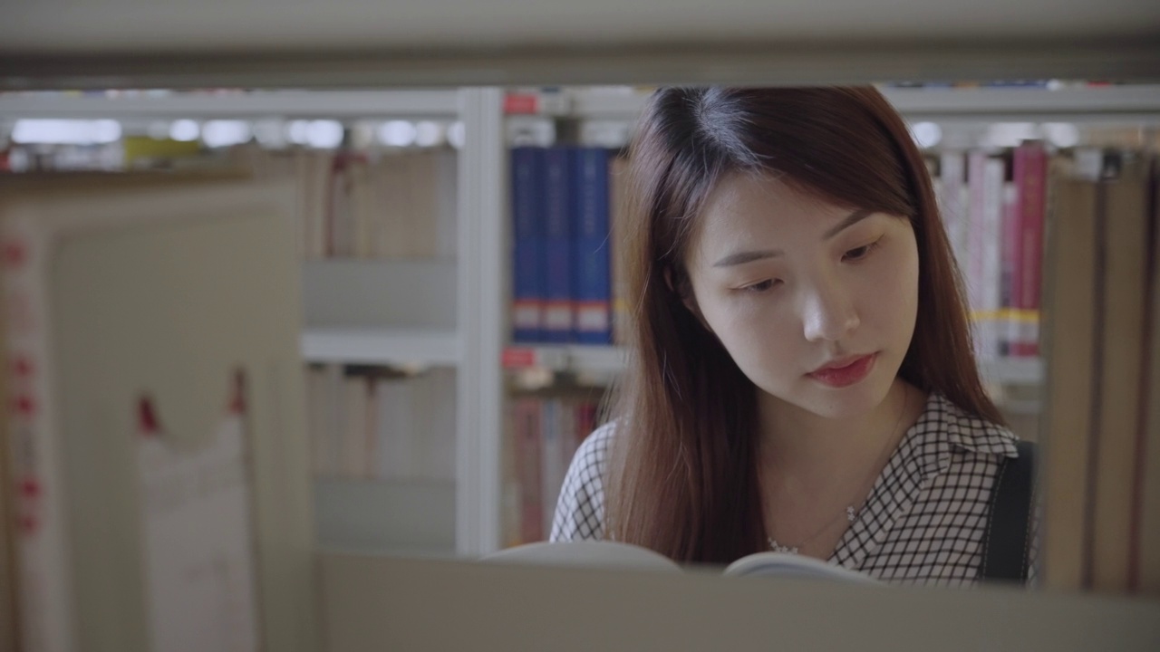 年轻的亚洲学生阅读书籍视频购买