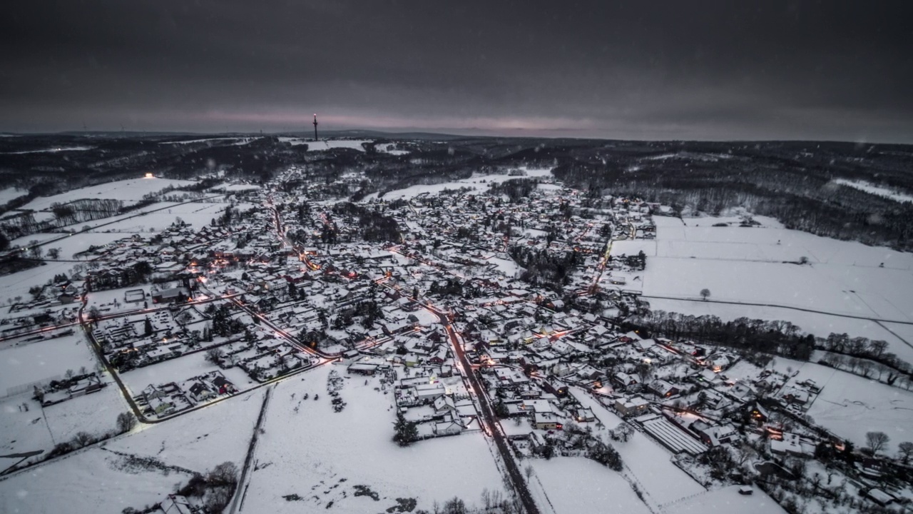 雪落在一个德国村庄的前面，被冬季景观包围-鸟瞰图视频素材