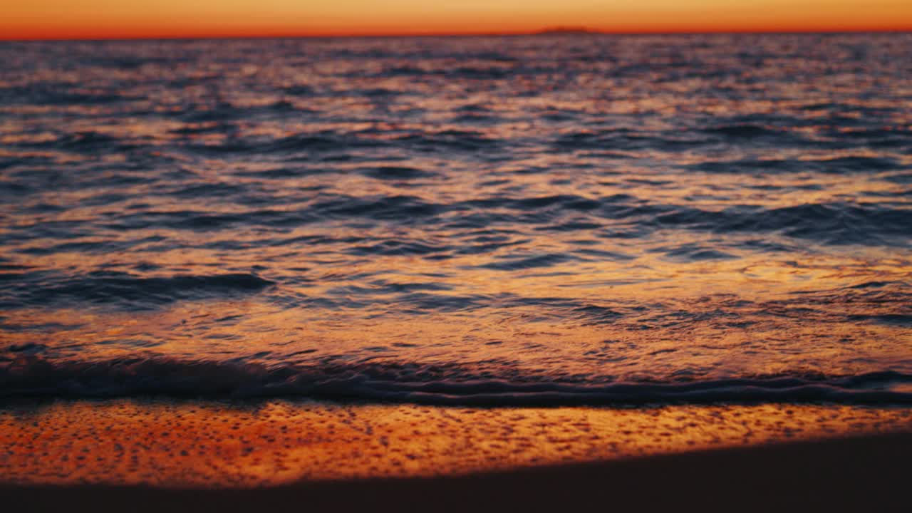 慢动作的风景全景海景与田园般的海浪在日落。视频下载