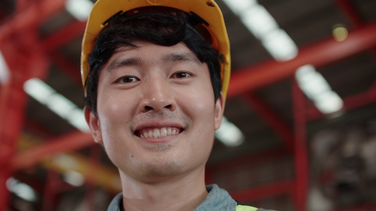 一副亚洲人的笑脸，他在工厂里工作得很开心。视频下载