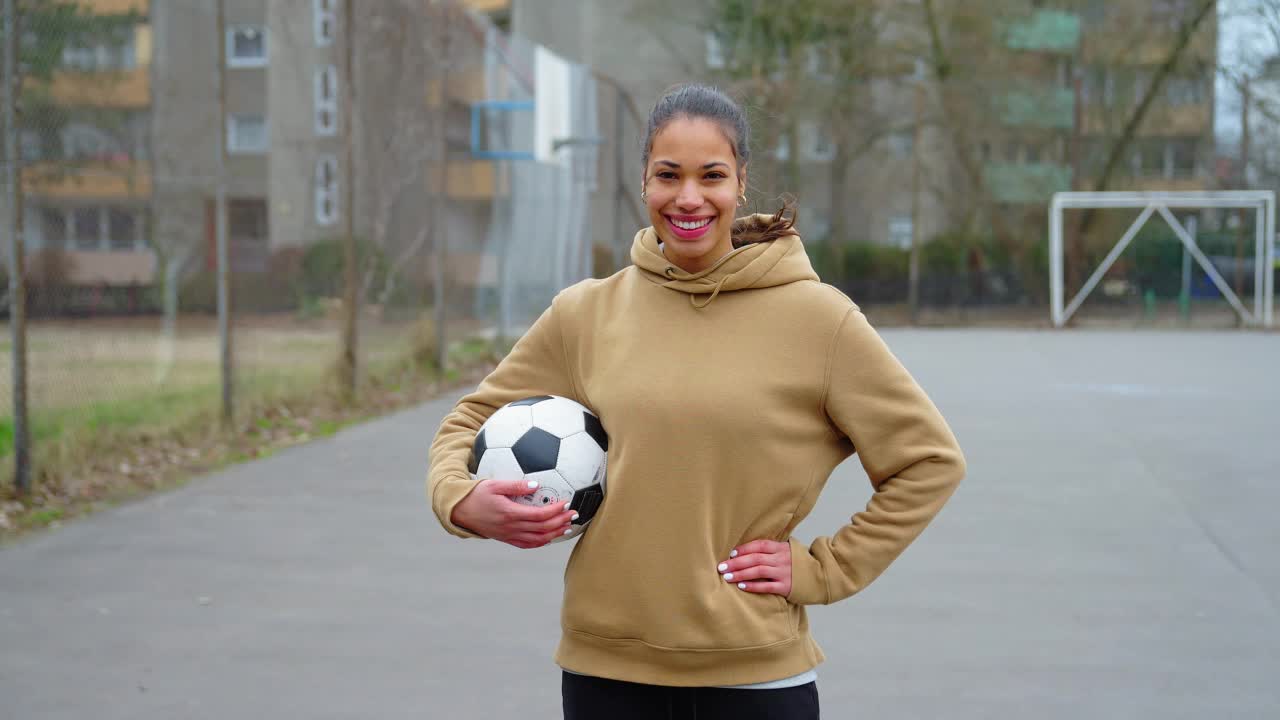 一个快乐的女足球运动员站在体育场上的肖像。视频下载